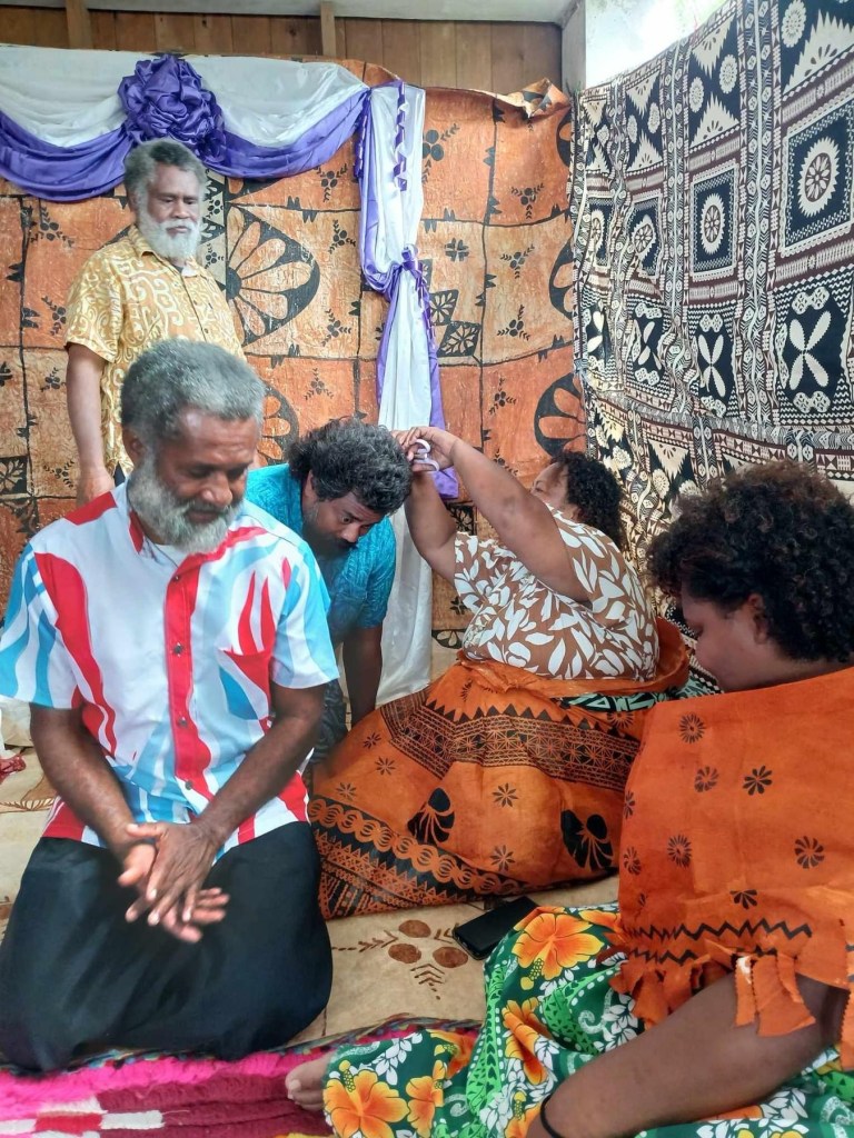 Three men getting their hair cut symbolically by two women. A ritual to lift a taboo. 